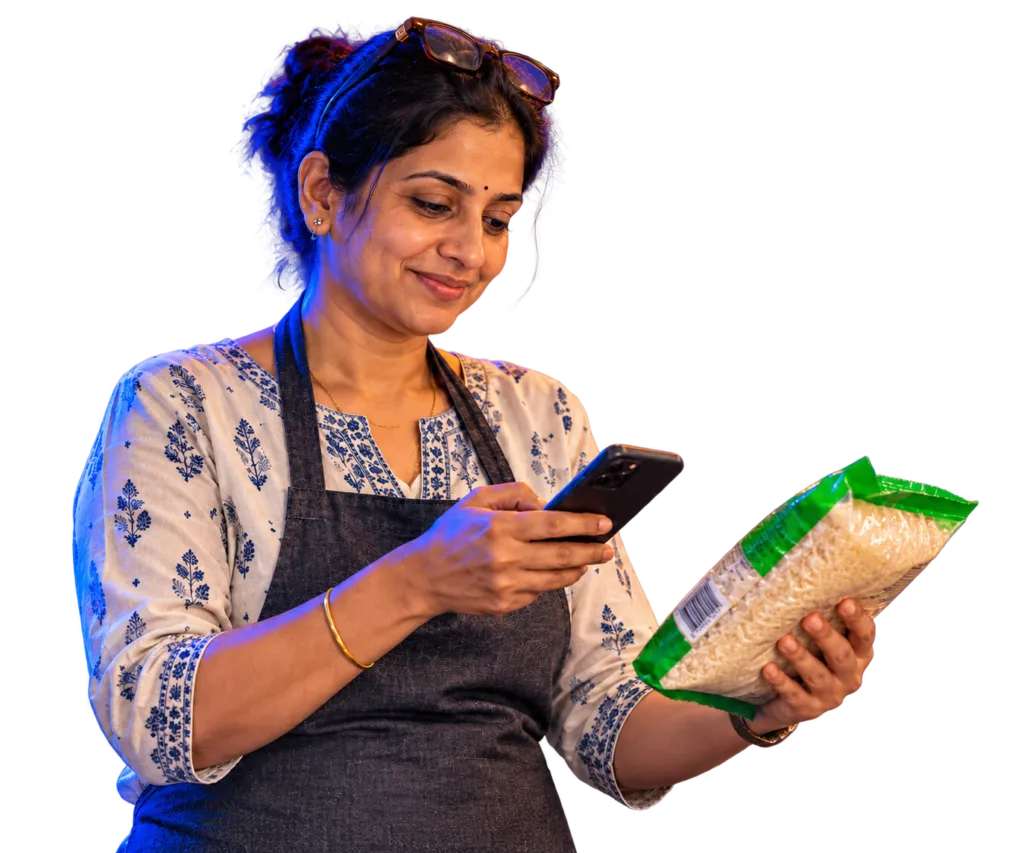 Shop owner smiling as she scans a packet of basmati rice with her phone